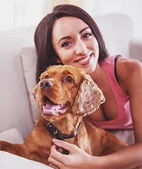 Resident on apartment sofa with her dog by her side