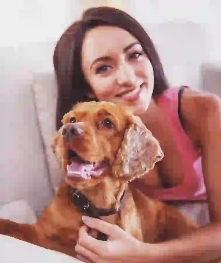 Resident on apartment sofa with her dog by her side